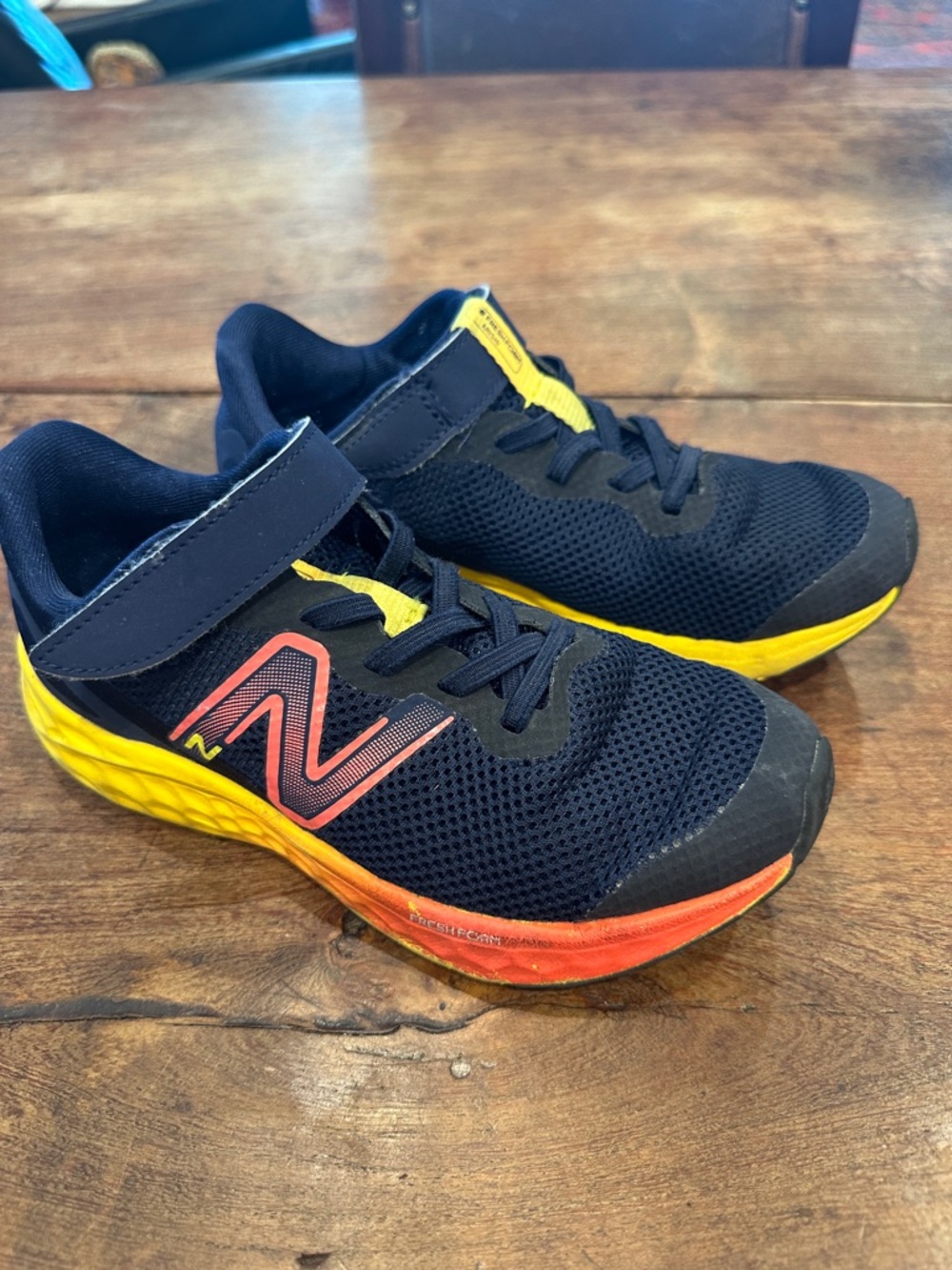 New Balance Kids Navy Sneakers with Yellow and Orange Accents